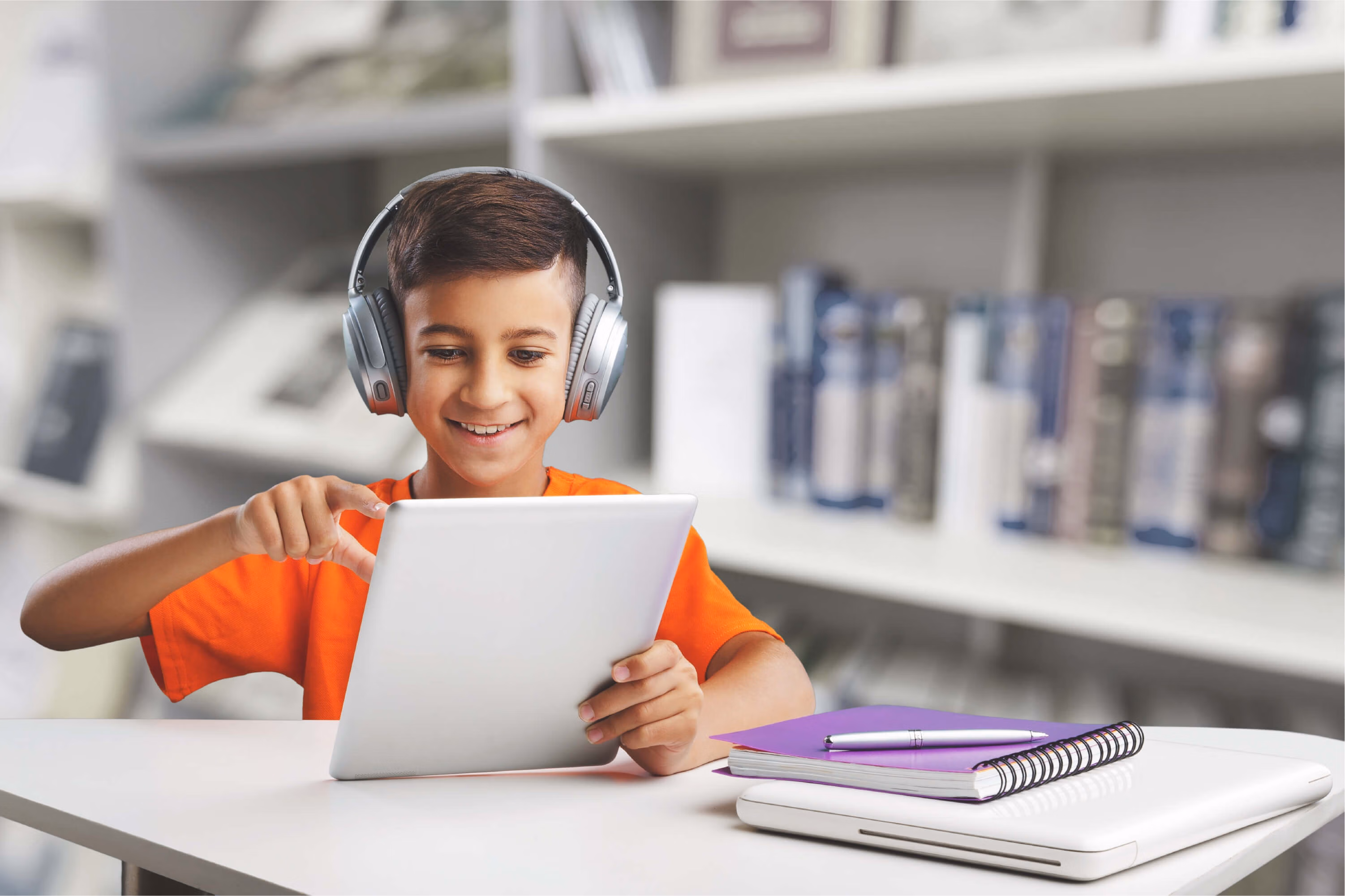 Un enfant devant un ordinateur posé sur une table.
